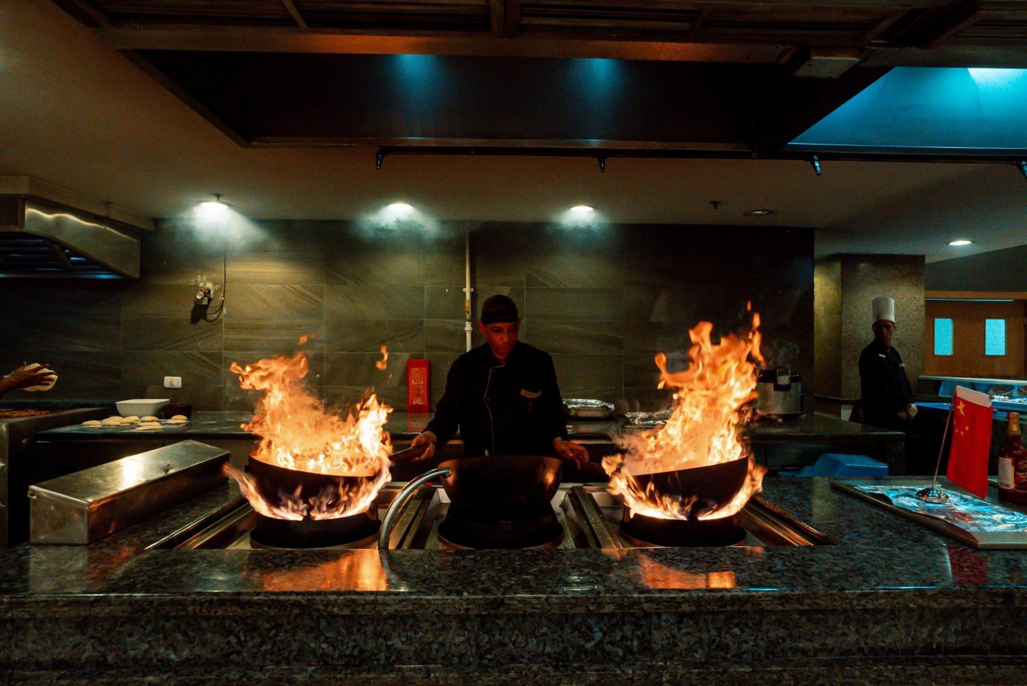 The V Luxury Resort Sahl Hasheesh Hurghada Eksteriør billede A chef cooking with a wok