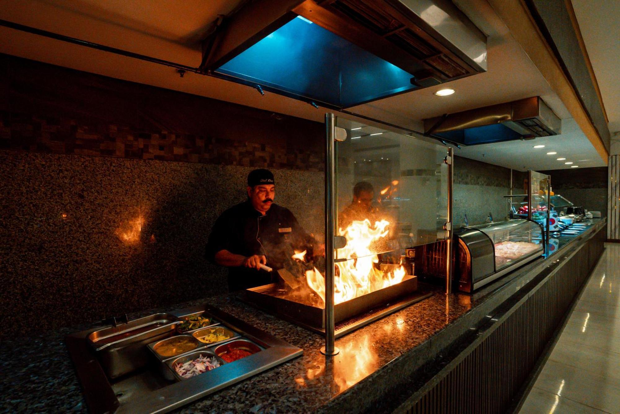 The V Luxury Resort Sahl Hasheesh Hurghada Eksteriør billede A chef cooking with a flaming torch