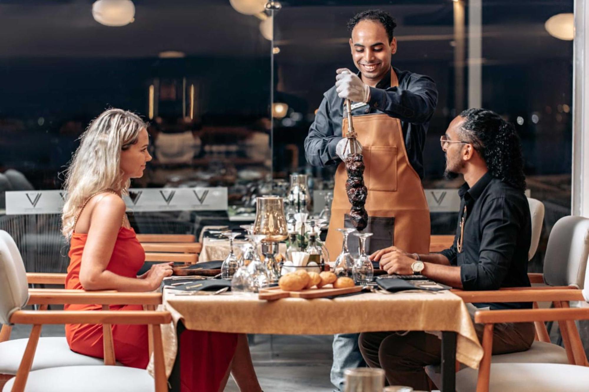 The V Luxury Resort Sahl Hasheesh Hurghada Eksteriør billede A waiter serving a couple at a restaurant